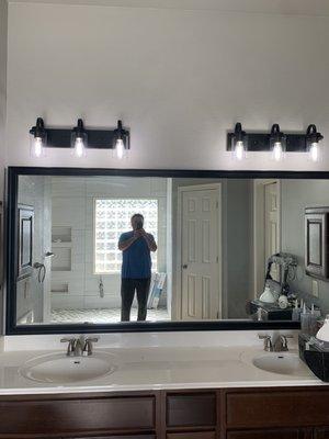 new framed mirror, beautiful faucets and modern light fixtures