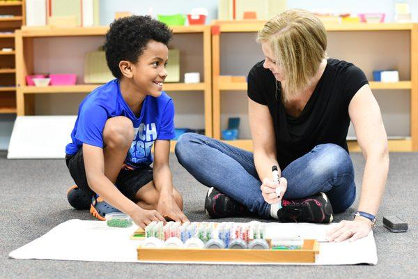 West Side Montessori student working with a teacher.