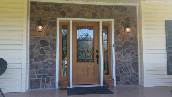 a new front door along with a stone surround around the door.. talk about a great curb apeal