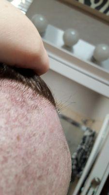 Close up of uneven shave and part