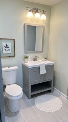 Design & install by Maeko. Paint, Drywall, Toilet, Vanity, Mirror, light fixture, trim, flooring all chosen and installed.