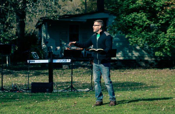 Pastor Josh preaching in an outdoor service.