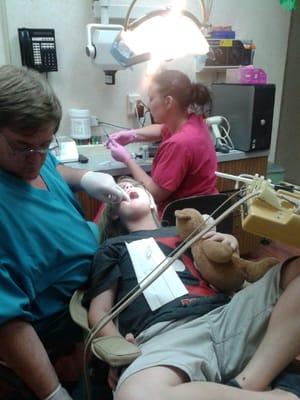 Dr Heuszel putting on my son's braces