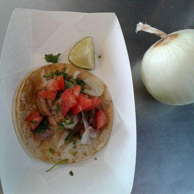 Carnitas Taco garnish with cilantro onions and tomatoes