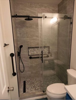 Finished bathtub conversion with custom shower pan, and matte black hardware.