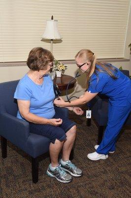 A nurse works with a home health care patient.