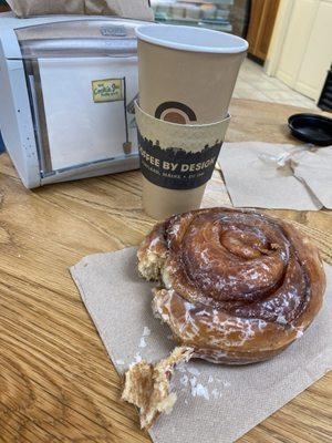 Enjoying a delicious, very large cinnamon bun and coffee.