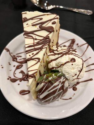 House made cheesecake, with house whip cream, chocolate covered strawberry, and chocolate drizzle.