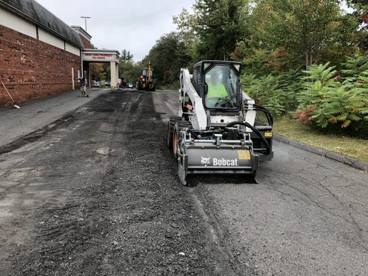 Asphalt Services: Grinding cracked and broken Asphalt before putting down new asphalt for commercial business.