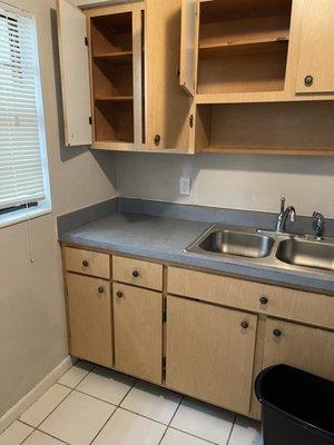 Wiped down sink and cabinet. Removed left behind dishes and appliances!