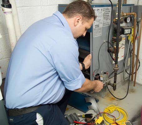 A technician performing a gas furnace repair.