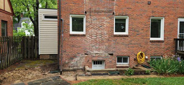 Before - drainage disaster, holes in wall, misplaced flagstone, and dangerous stairwell