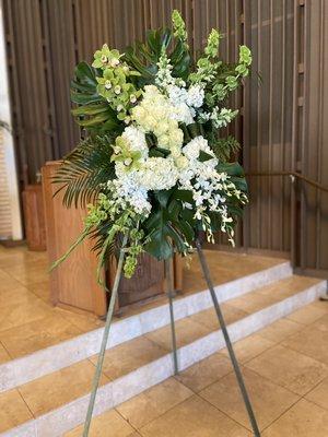 White standing spray for celebration of life. To place an order call (949)464-0509 or visit https://lagunabeachflorist.com .