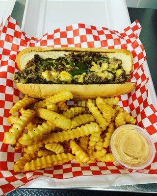 100% Ribeye Cheesesteak with grilled onions and peppers, American cheese with fries.