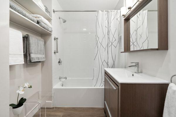 Bathtub/Shower fixtures and tile-like wall surround.