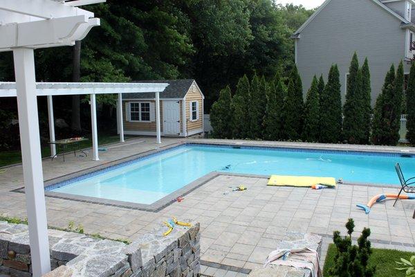 concrete paver pooldeck with granite stone wall