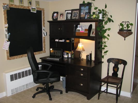 In home office space W/ custom chalk board edged with corks and Hooks for hanging small buckets filled with tacks and chalk.