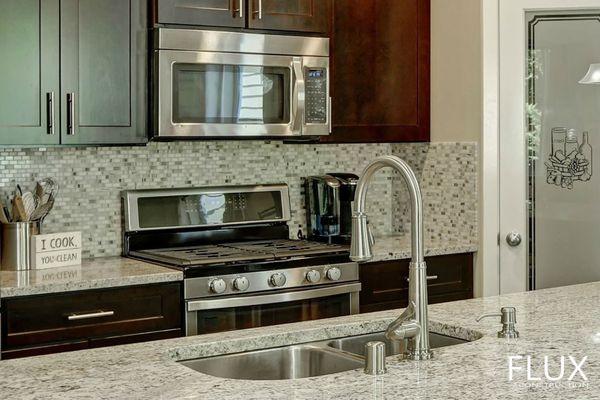 Quartz island, stainless steel undermount sink and a tall faucet.