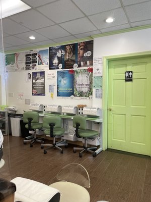 Restroom and nail dryers across from pedicure chairs.