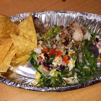 Mexican Burrito bowl with salsa corn chips.