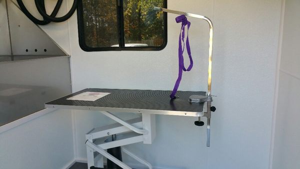 Inside the trailer, hydraulic grooming table with adjustable grooming arm.