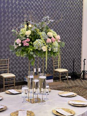 Elegant pastels tall wedding centerpieces featuring hydrangeas, roses and delphinium with draping eucalyptus