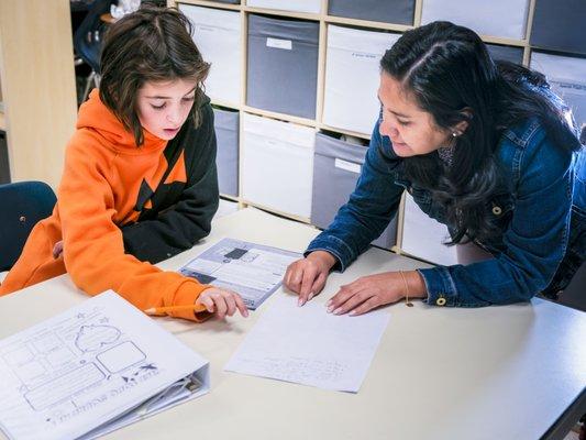 Spanish teacher Jackie reviews an assignment with a 6th grade student.