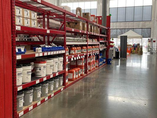 Long shelving unit with janitorial supplies in tubs and bottles at Jon-Don St. Louis