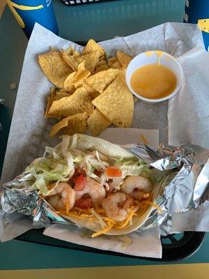 Shrimp taco and chips with queso.