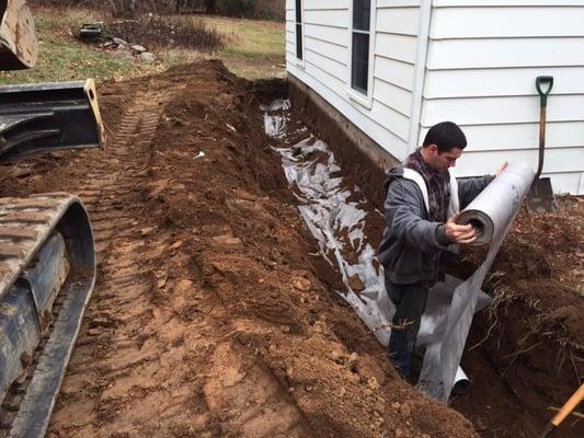 foundation drain in Andover ct laying down filter fabric over stone.