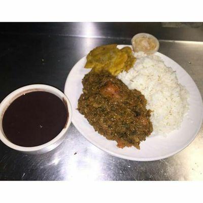 White rice with Black-Bean Sauce (Sos Pwa Nwa) Legumes, pressed plantains, Haitian Pickled.