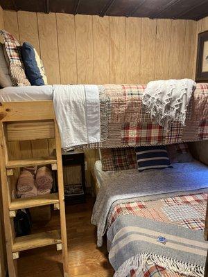 Full bed with twin bunk in small cabin.