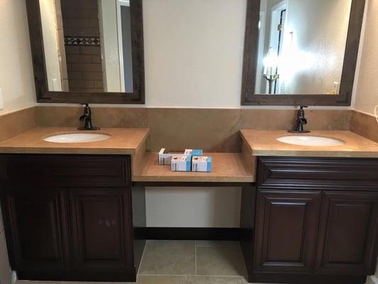 Travertine bathroom counters with under-mount sinks.