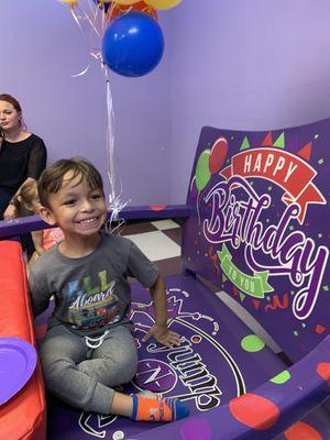 Happy birthday boy in the party room chair.