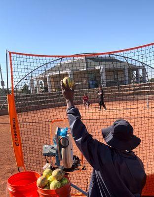 Machine specialist distributing balls during a batting session.