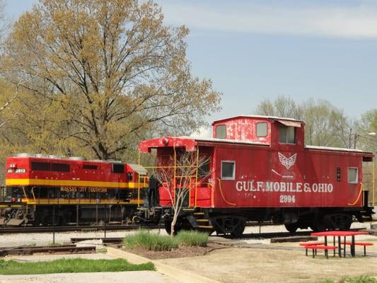 Retired caboose, you can go onboard during museum hours...the big engine in background just happened to be passing by, it isn't always there