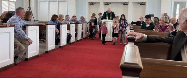 Kids in worship with Pastor moving the Baptism Font