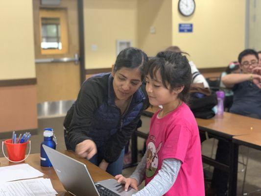 Manisha working with a student on Scratch.