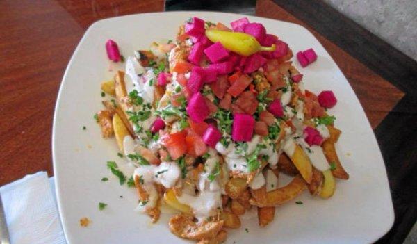 Chicken Shawarma Fries! Golden crisp Fries topped chicken, tahini sauce as well as our garlic sauce tomatoes pickled turnips and parsley!