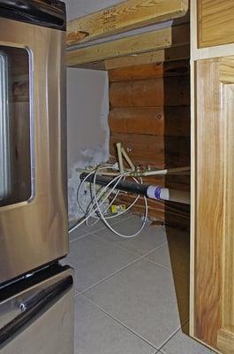 Space between stove and cabinet in kitchen, complete with rodent bait.