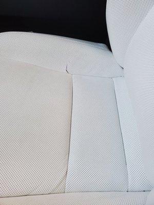 Tear in the side of white perforated seat (Before)