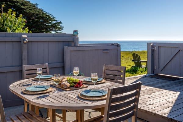 Dining al fresco with the ocean and Adirondack chairs beyond