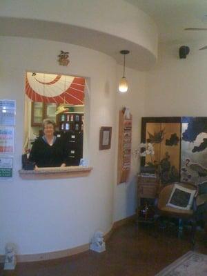 Dee Ann Newbold, L.Ac. at the check-in window of her office.