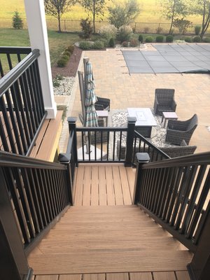 Deck steps down to another outdoor living area and pool.  Shown is Trex decking with Timbertech black railing system.