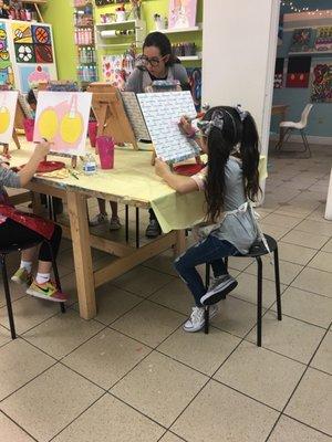 My daughter before starting adding her name to her painting