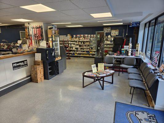 To the right is the waiting area, the safes, and the door knobs and deadbolts. Also our handgun and shotgun selection.