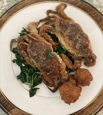 Plated pan seared soft shell crab with lemon butter sauce and steamed spinach with hush puppies!