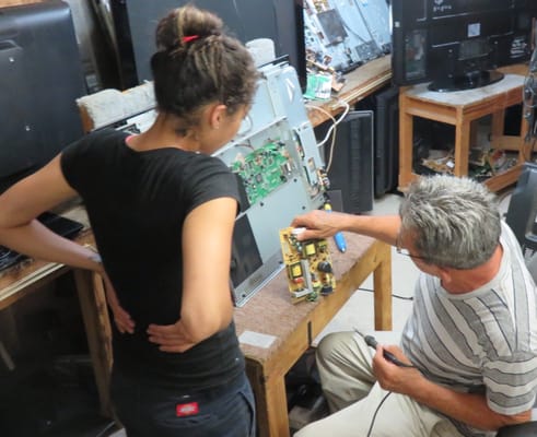 Two technicians confer on a power supply problem on an LCD TV