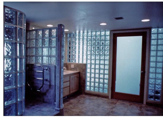 An upscale bathroom with a exercise room through the door.