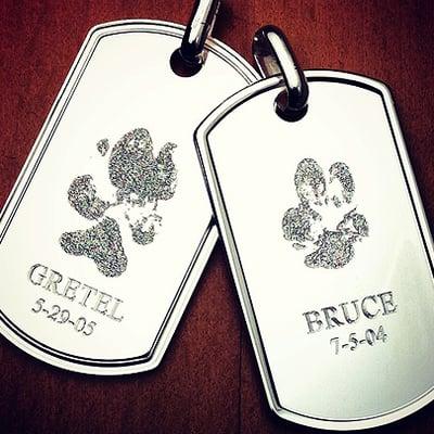 Custom engraved sterling silver dog tags with owner's pet dogs paw prints etch engraved from emailed photographs.